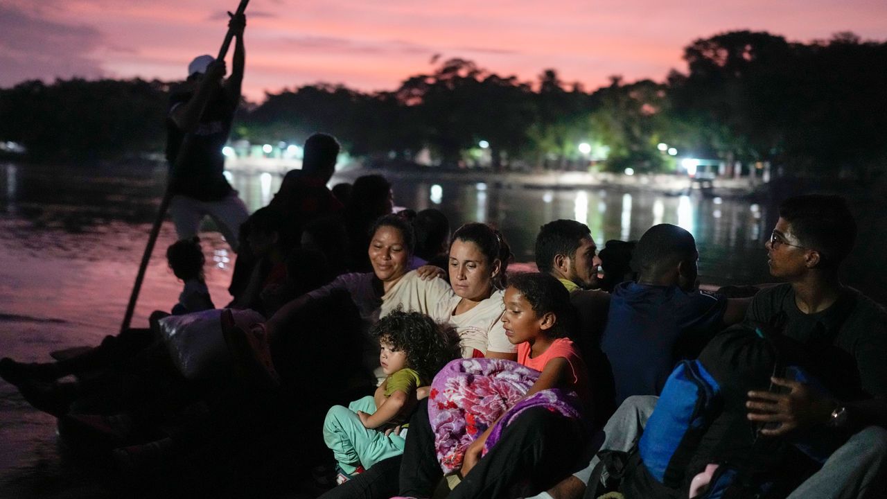 Venezuelan migrant hugs her children as she crosses the Suchiate River.