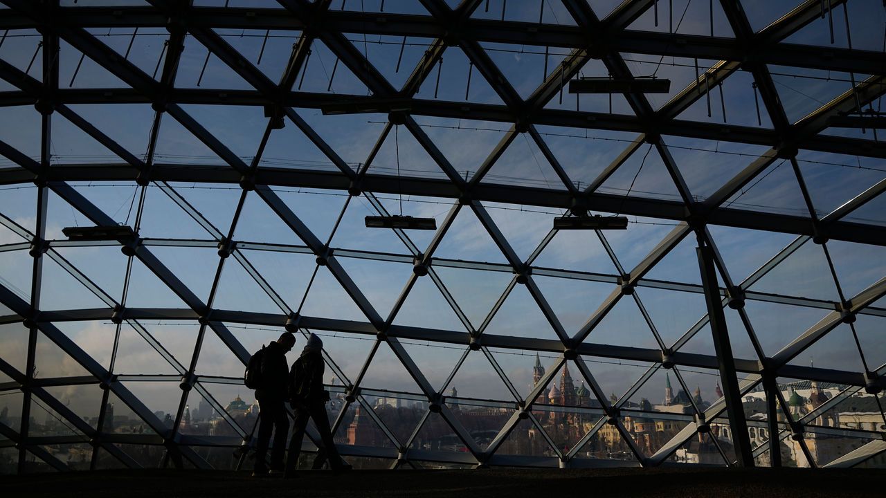 People walk at Zaryadye park with the Kremlin and St. Basil's Cathedral in the background in Moscow, Russia.