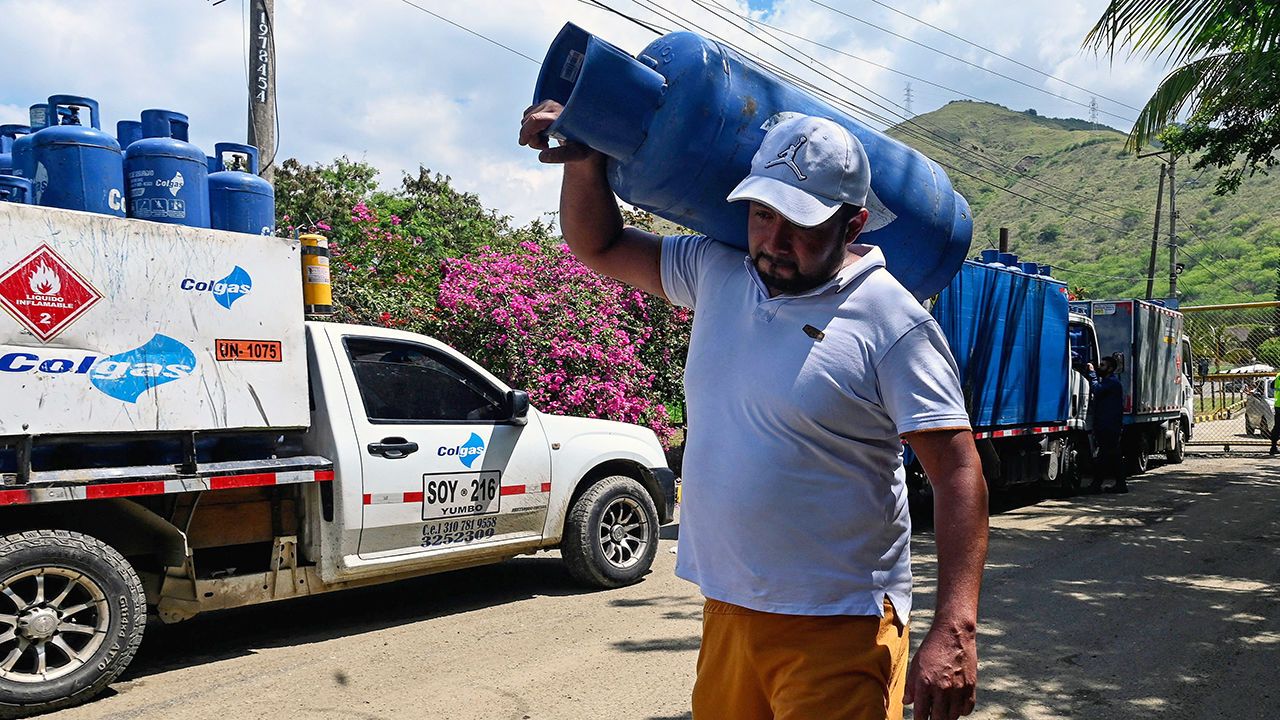 A man carries a gas cylinder near a gas distribuitor in Yumbo, department of Valle del Cauca, Colombia.