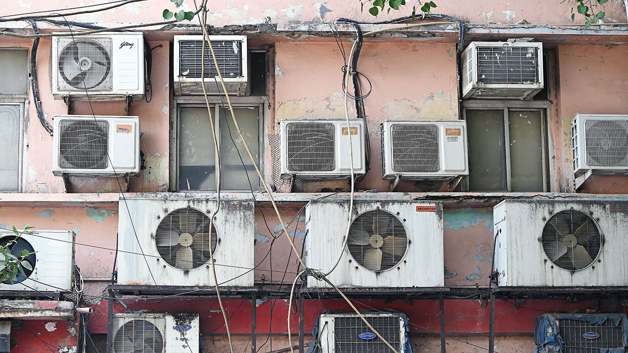 Air conditioning units hang from a building during high temperatures in New Delhi, India