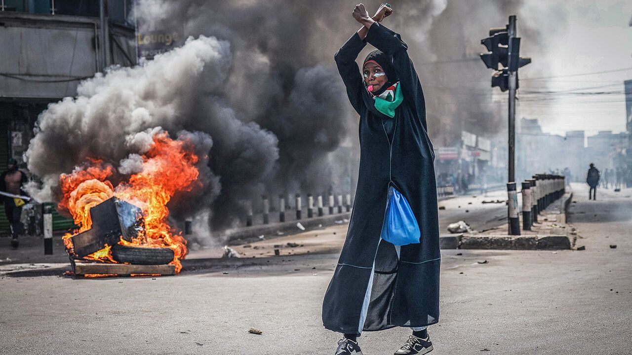A protester reacts in front of a burning barricade in downtown Nairobi, Kenya on June 25, 2025
