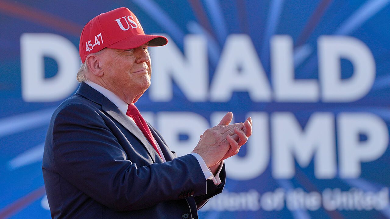 President Donald Trump claps his hands on stage at a rally in Des Moines, Iowa, USA