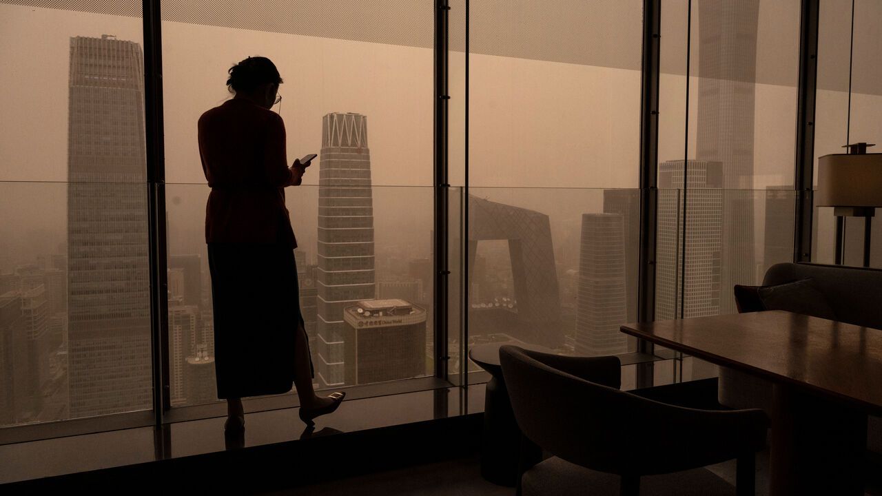 Silhouette of a woman looking out a window in China.