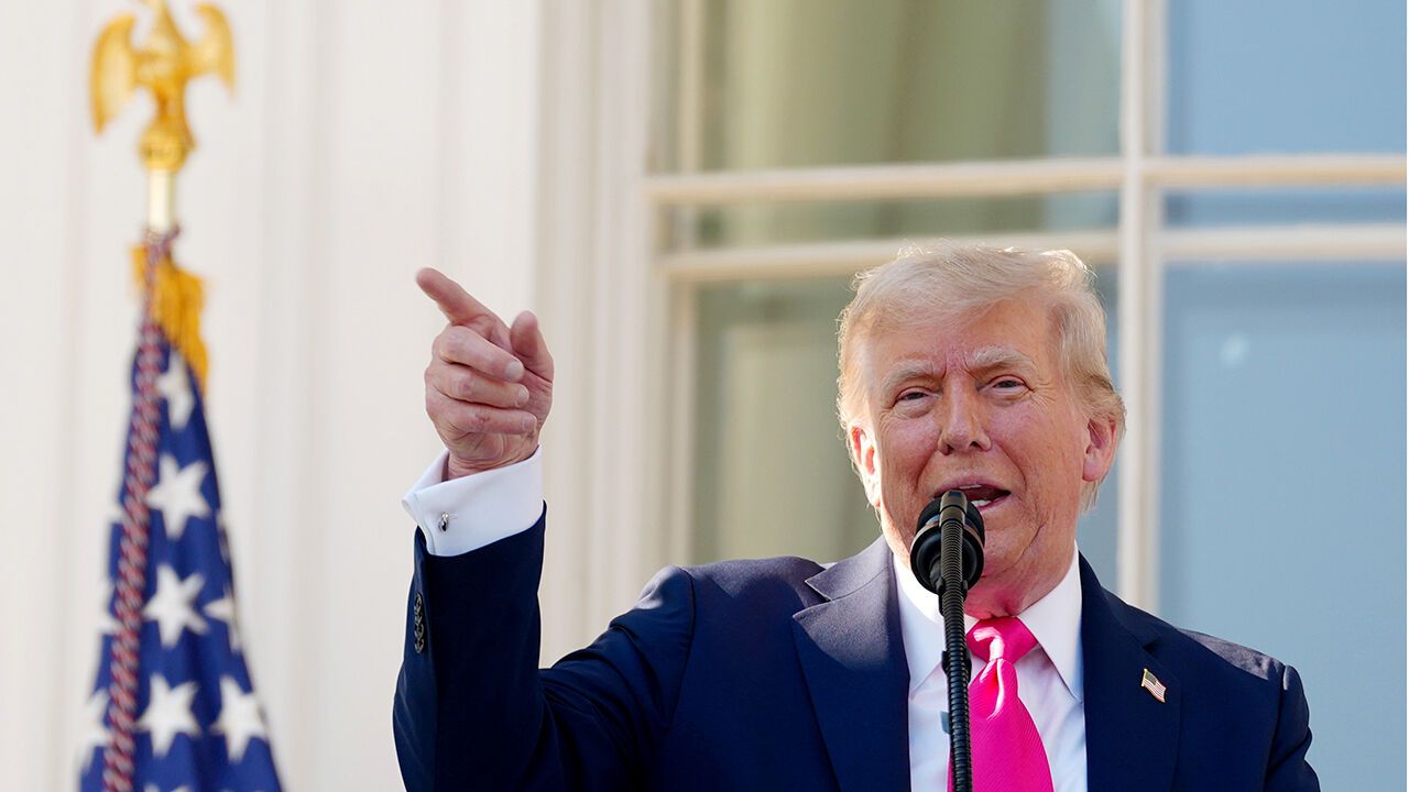 President Donald J Trump points as he speaks from the White House balcony