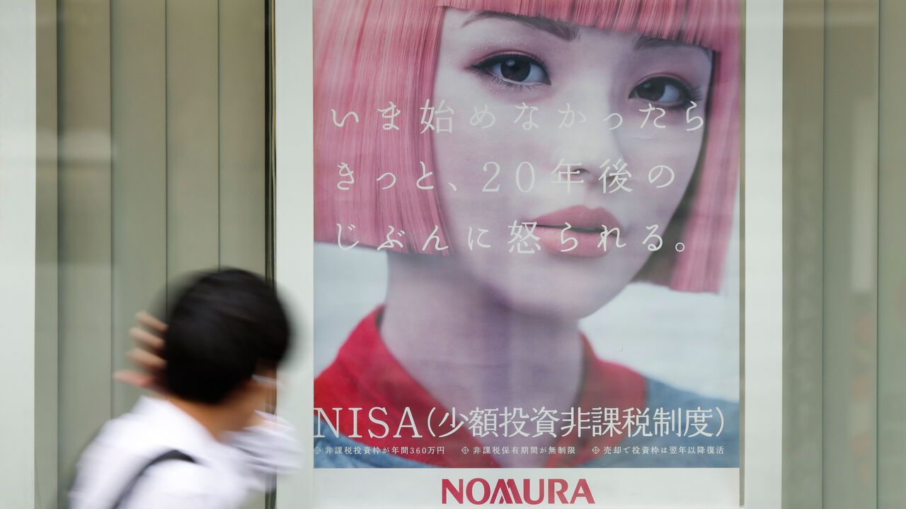 A man looks at an advertisement for the Nippon Individual Savings Account (NISA) displayed at a branch of Nomura Securities Co., a unit of Nomura Holdings Inc., in the Kichijoji area of Tokyo, Japan.