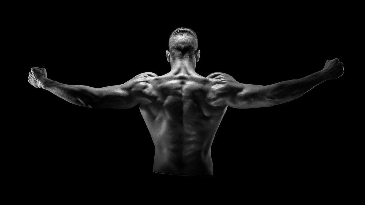 Young man with strong body showing back muscles
