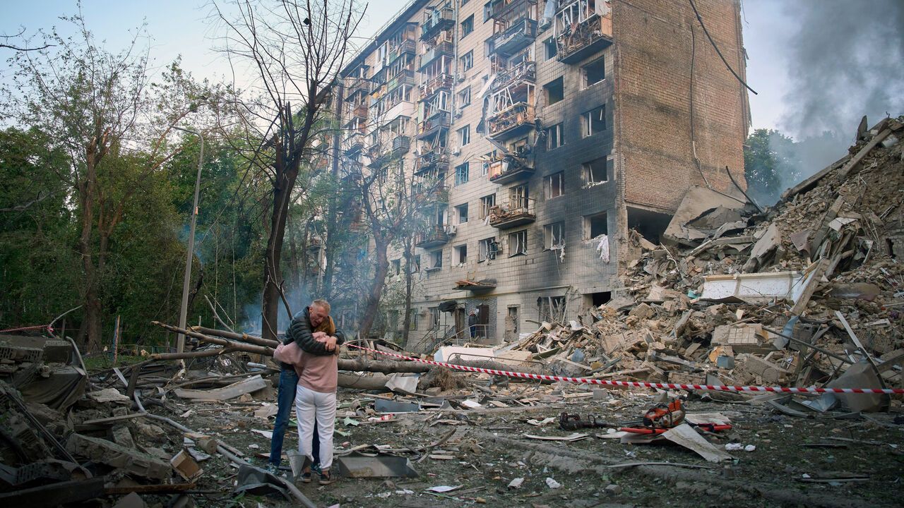 Residents embrace after a Russian missile hit a multi-storey apartment